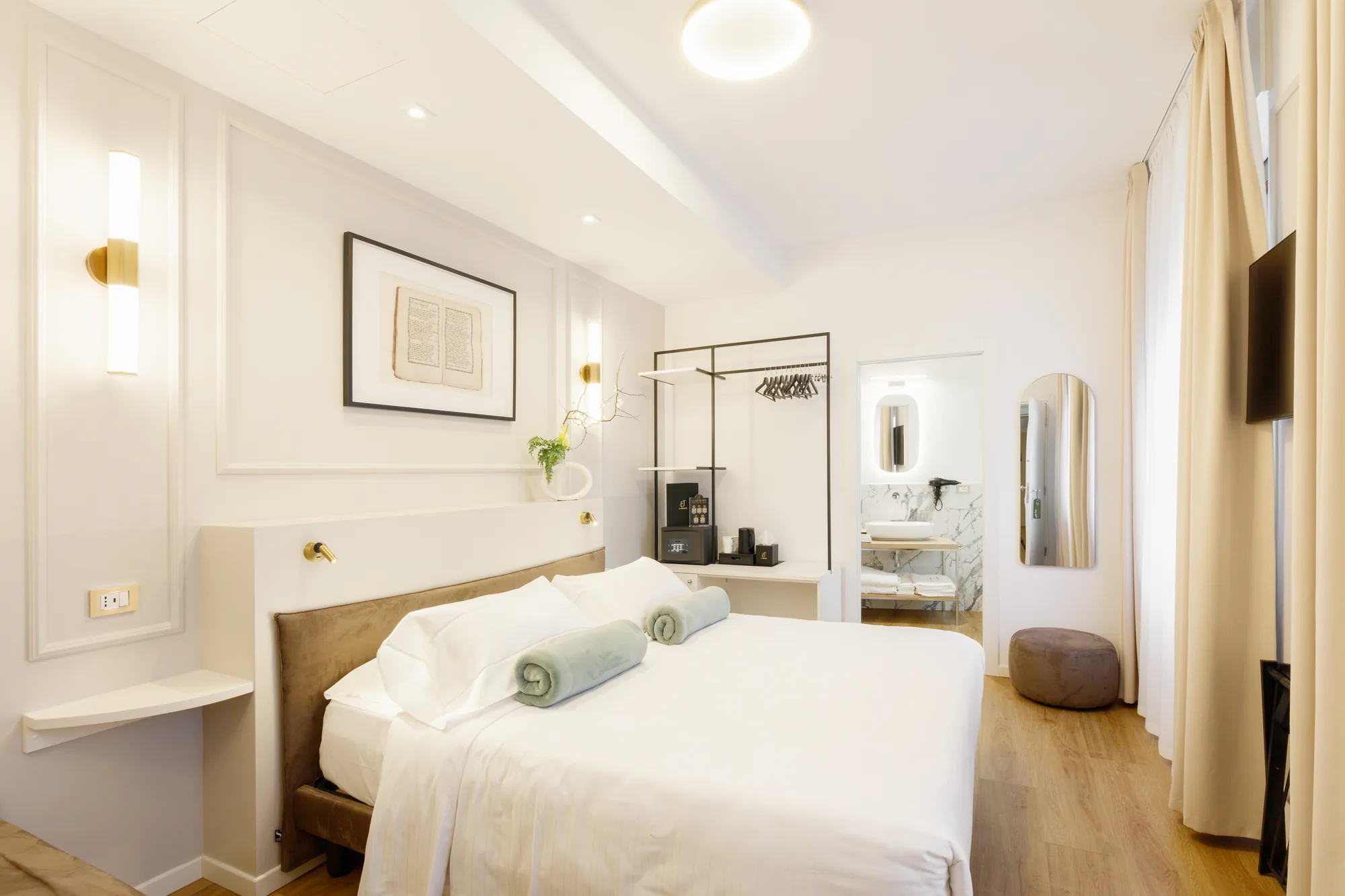 Camera da letto elegante con letto matrimoniale, armadio, TV e bagno visibile sullo sfondo