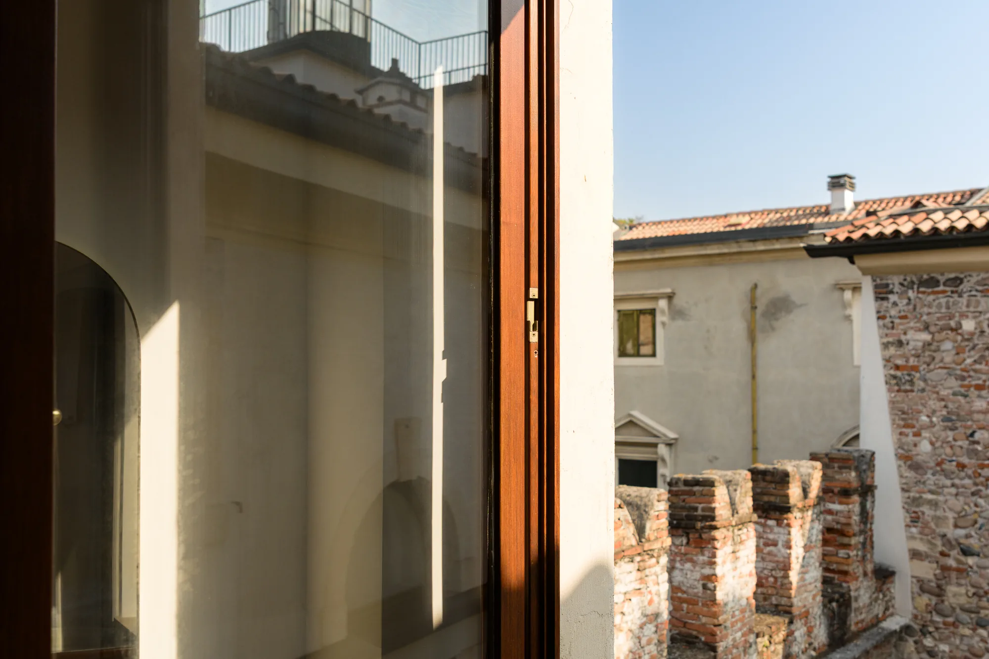 Vista di un muro di mattoni e di un edificio adiacente attraverso una finestra aperta