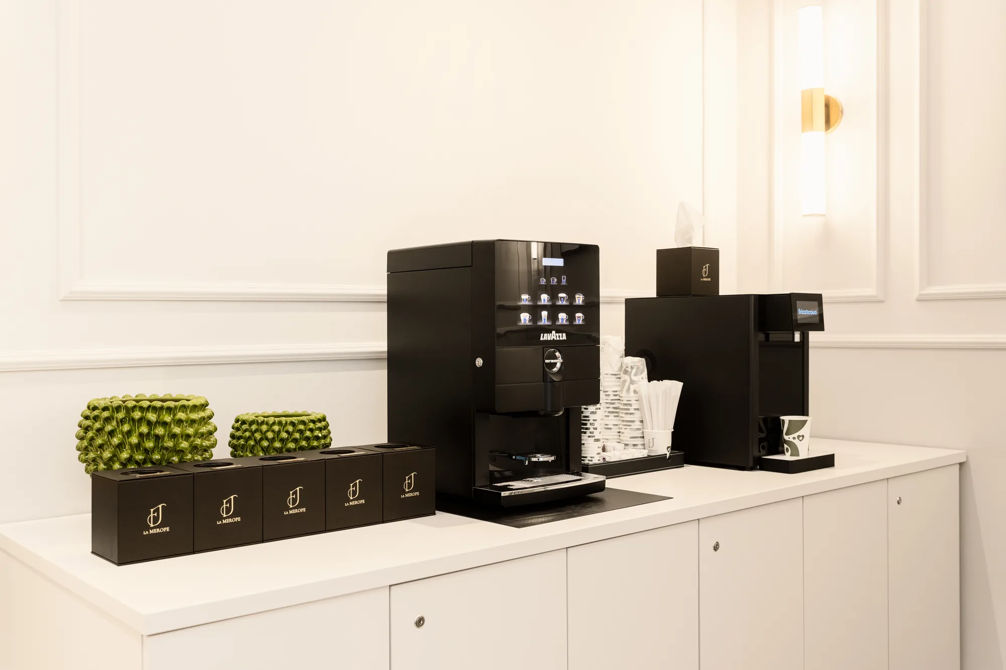 Distributore automatico di caffè Lavazza con accessori e decorazioni sul piano di lavoro